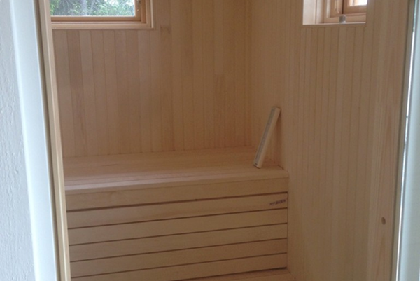 Inredning i en nybyggd bastu med träpanel och sittbänk i ljust trä.
